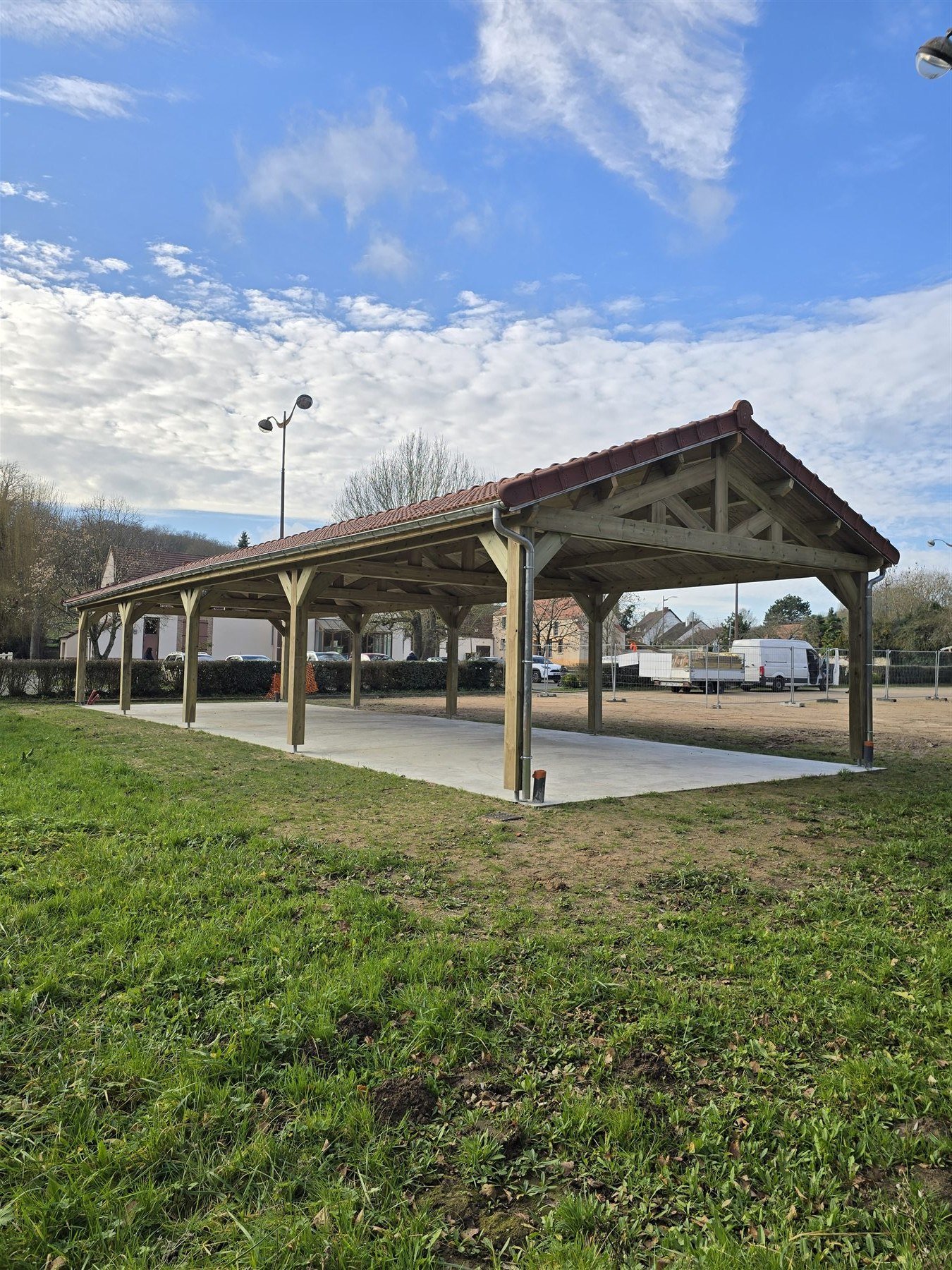 Charpente apparente et couverture en tuiles du carport de Vert